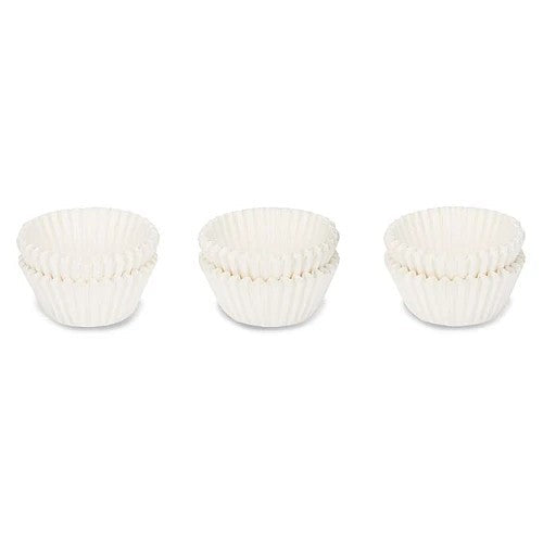 Zes kleine witte papieren pralinevormpjes in drie stapeltjes van twee op een witte achtergrond
