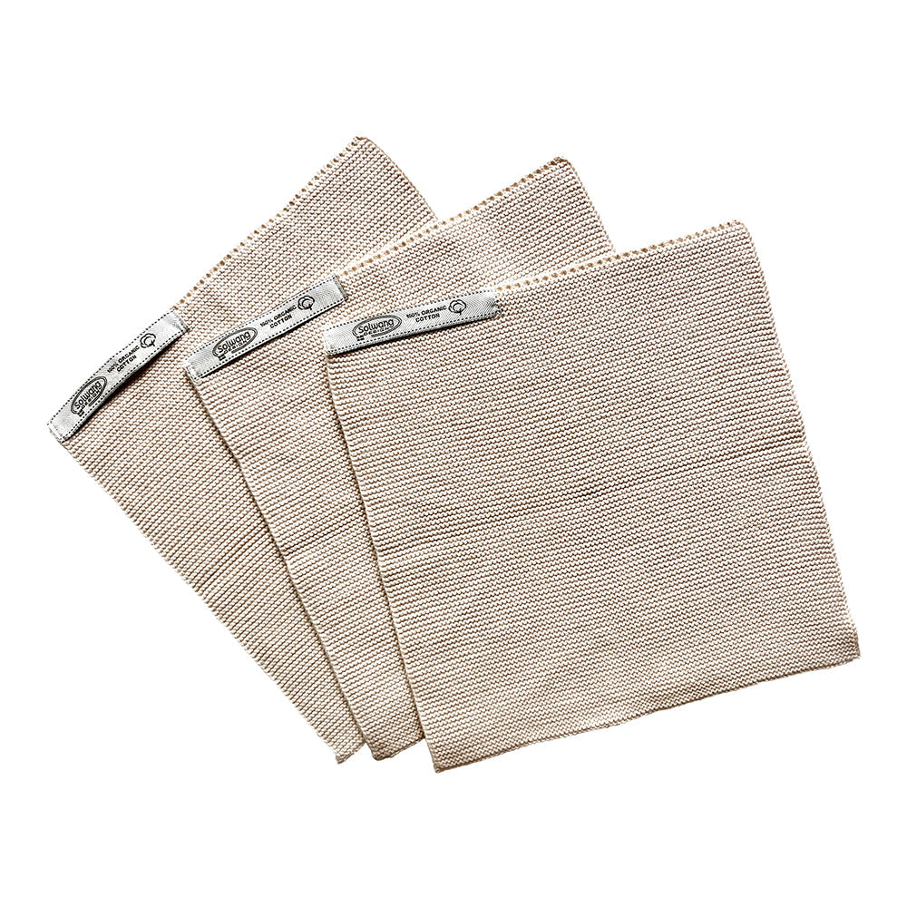 Solwang Design Vaatdoekjes set van 3 - Soft Nature drie gebreide doekjes gewaaierd over elkaar in verwante, zachte beige/naturel tinten met een subtiel kleurverschil tussen de doekjes, met het Solwang-label zichtbaar op elk doekje.