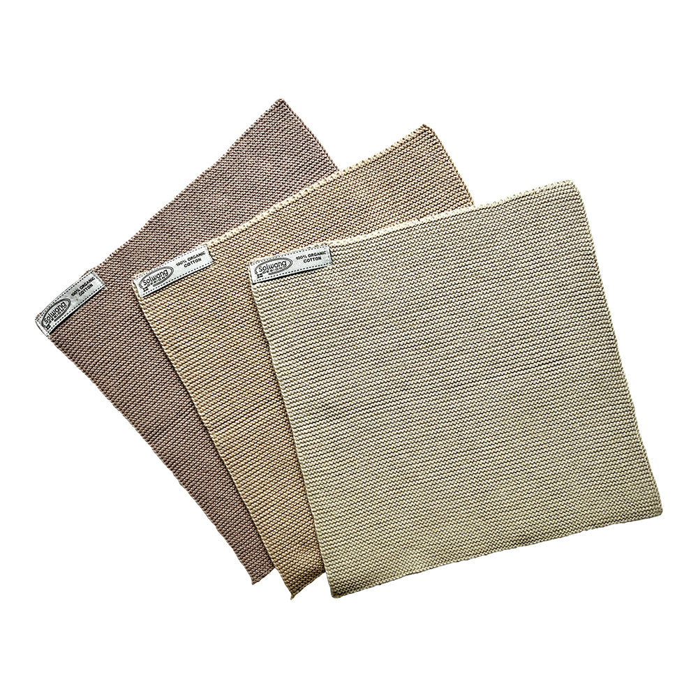 Solwang Design Vaatdoekjes set van 3 - Zand Combi drie gebreide doekjes gewaaierd over elkaar, van donker taupe/bruin achteraan via middenzand naar een lichte ecru/zand tint vooraan, met het Solwang-label zichtbaar op elk doekje.