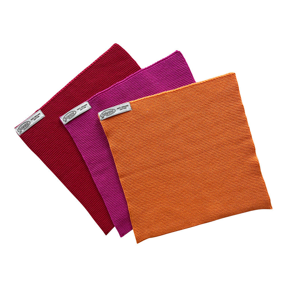 Solwang Design Vaatdoekjes set van 3 - Oranje/Roze/Rood drie vaatdoekjes waaiervormig over elkaar uitgespreid in bordeauxrood, roze/fuchsia en oranje, met gebreide structuur en het Solwang-label zichtbaar in de hoek van de doekjes.