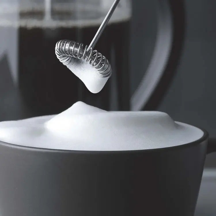 Aerolatte opschuimkop die melkschuim maakt op een cappuccino in een grijze mok
