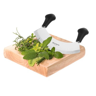 Westmark Uno Wiegemes, in gebruik om kruiden te hakken op een houten snijplank