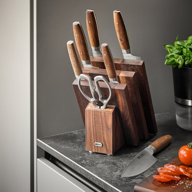 GEFU Magnetisch Messenblok Enno - Fan Design in de keuken gevuld met een schaar en vijf messen met houten handvat, op het werkblad naast tomaten, basilicum en een los mes op de snijplank