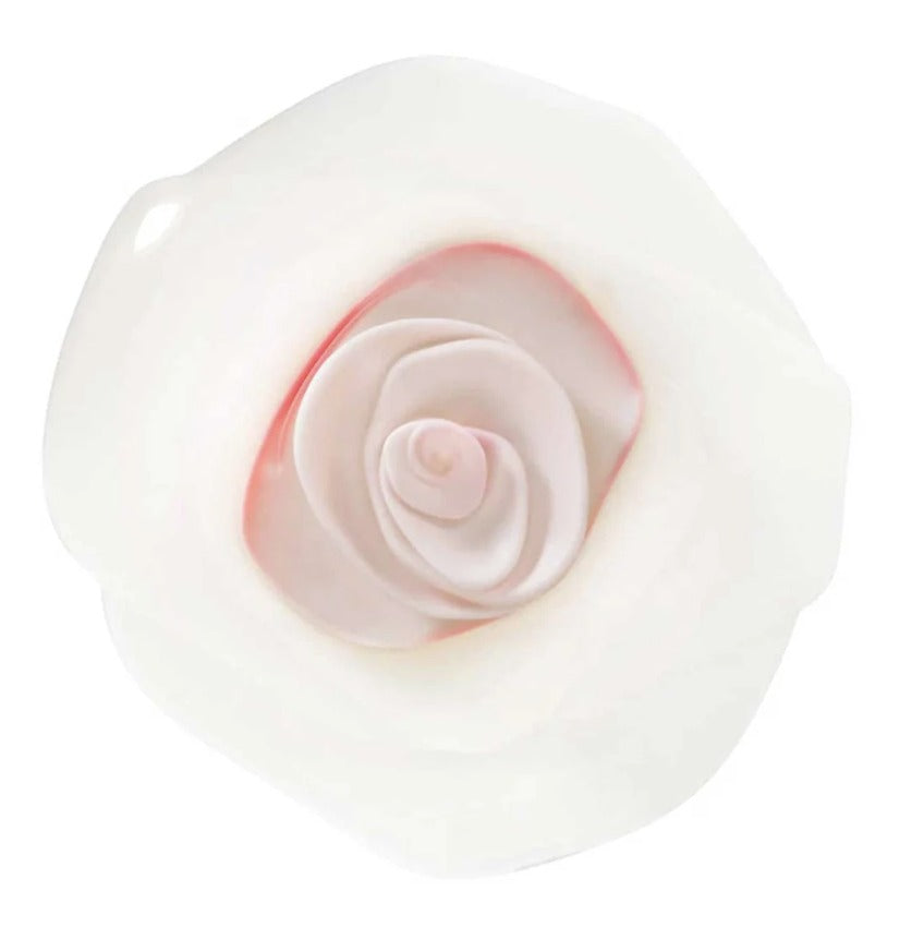 Een hand tilt het Charles Viancin Vershouddeksel Rose Wit van een glazen kommetje met gesneden aardbeien