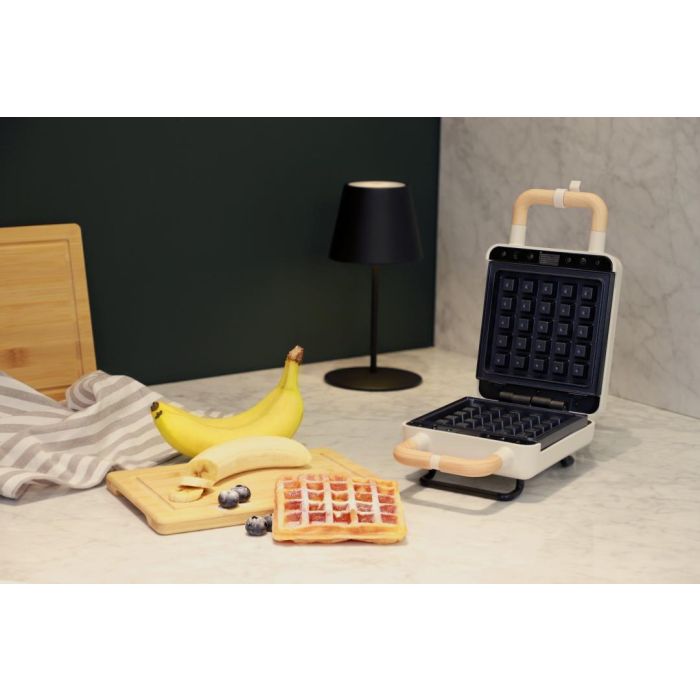 ADE wit wafel- en tosti-ijzer geopend op een aanrecht, met verse wafel en banaan
