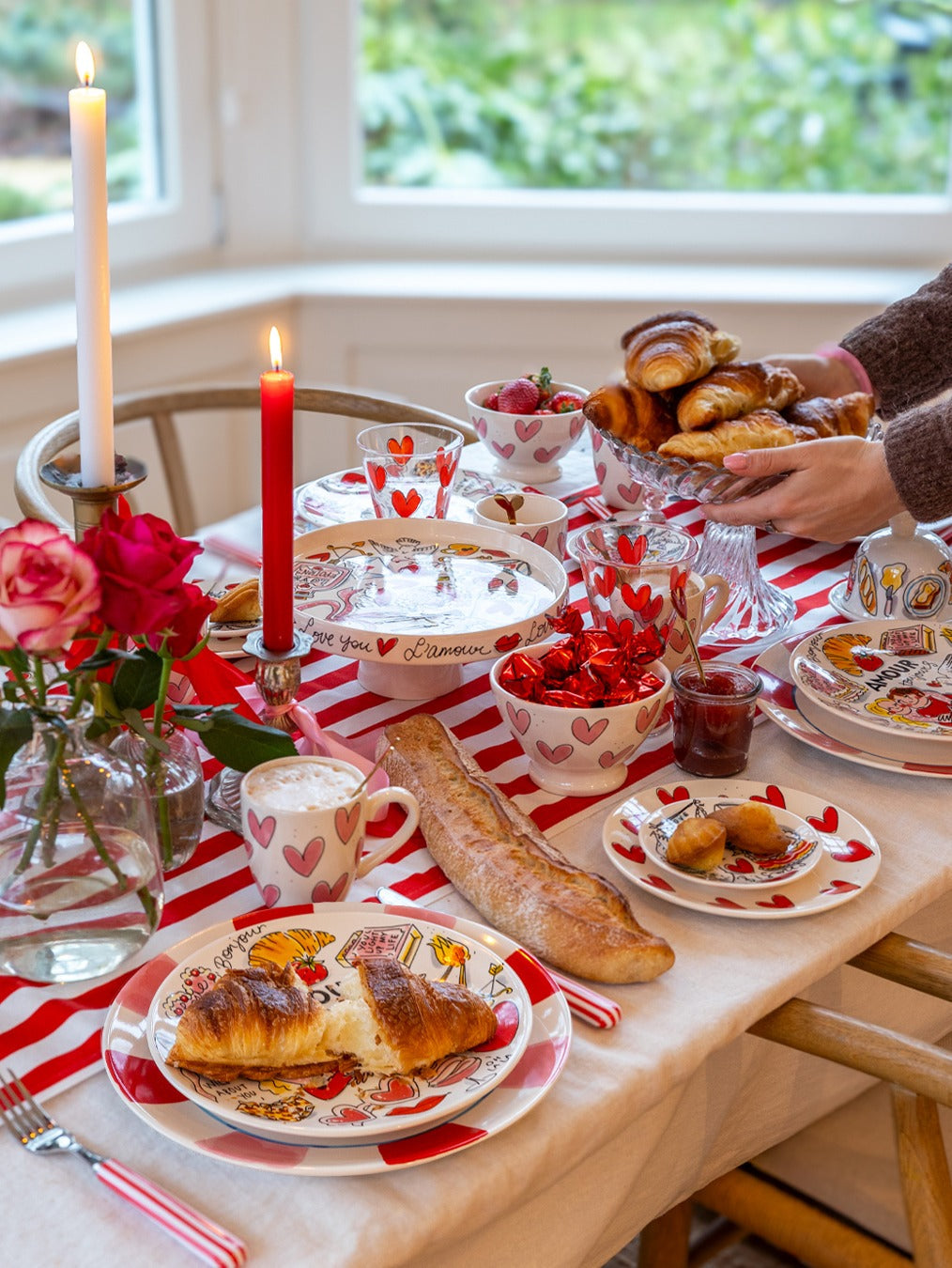 Blond Amsterdam Love bord Hearts op een gedekte tafel met croissants, kaarsen en rode rozen