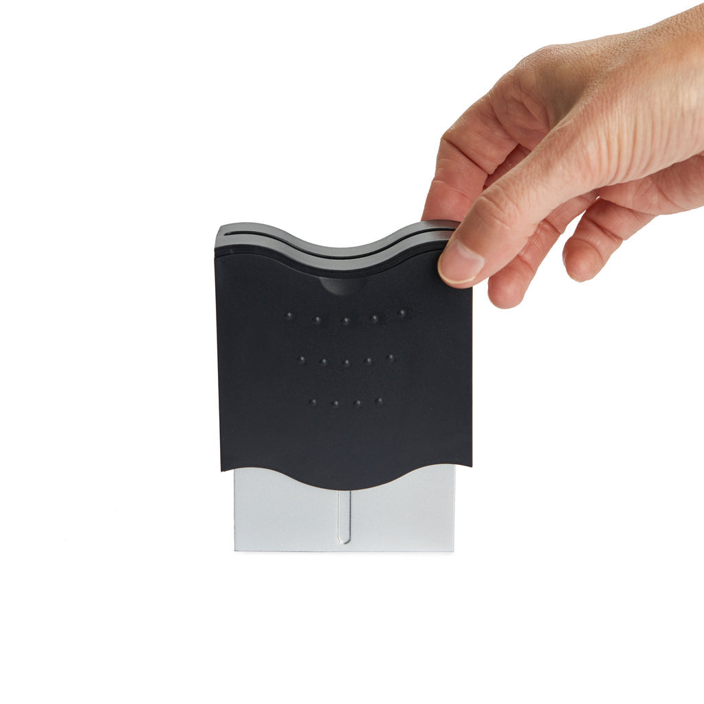 Zwarte Balvi Pick a Boo tandenstokerdispenser, vastgehouden in de hand tegen witte achtergrond
