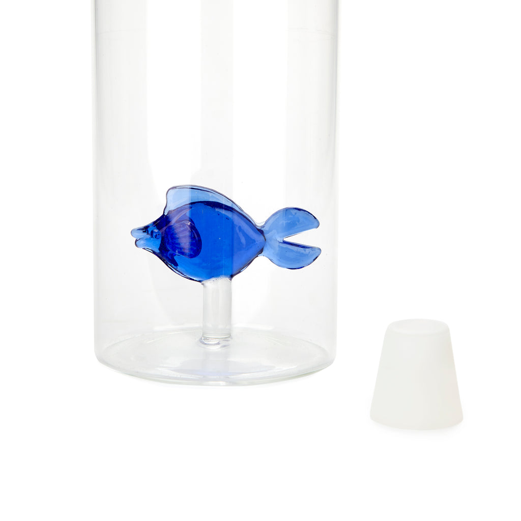 Detailopname van de Balvi glazen waterkaraf met blauw glazen visje erin en witte dop ernaast