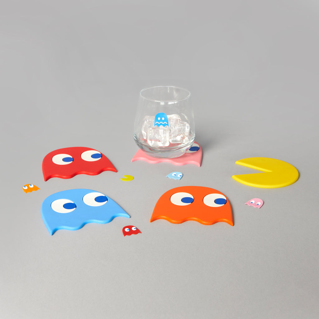 Balvi Pac-Man onderzetters met gekleurde spookjes, een glas rust op de roze onderzetter