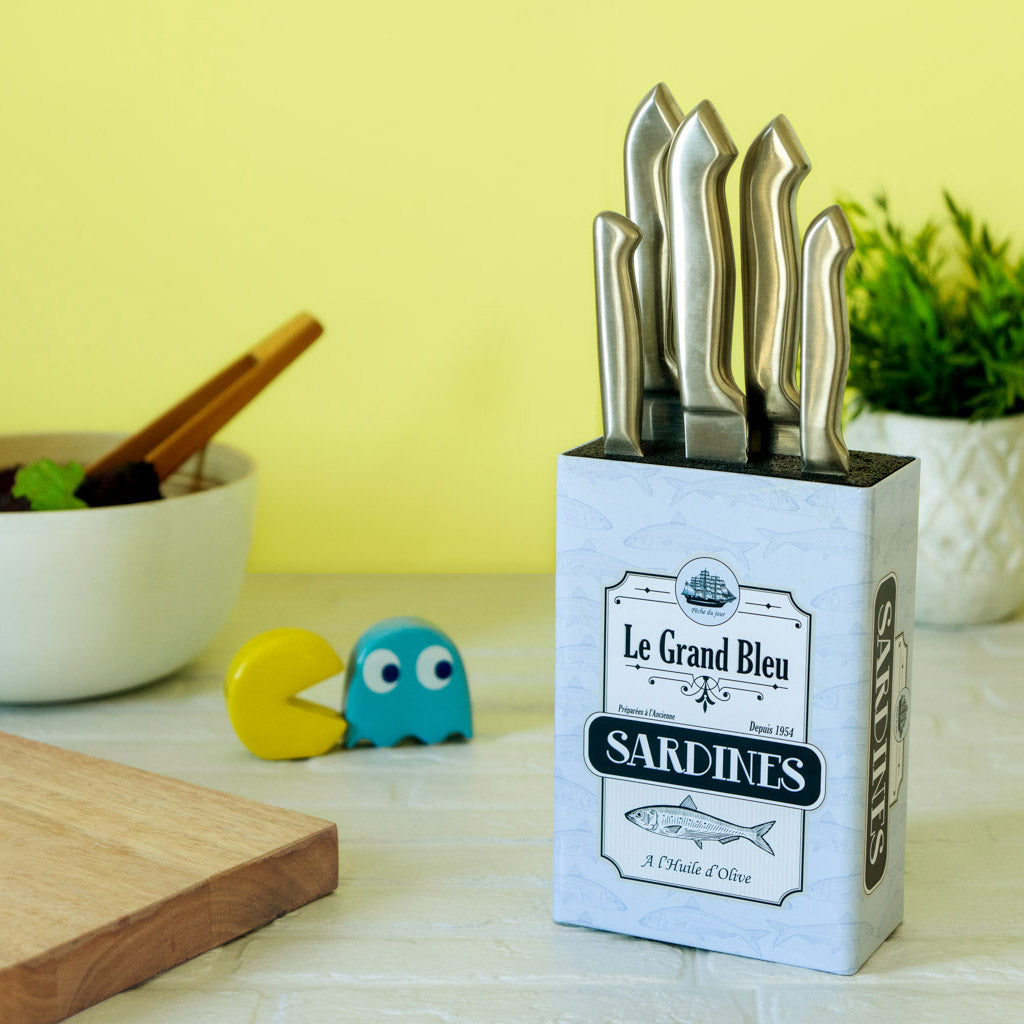 Balvi Messenblok Sardines, op gele achtergrond, gevuld met messen naast kleine figuurtjes
