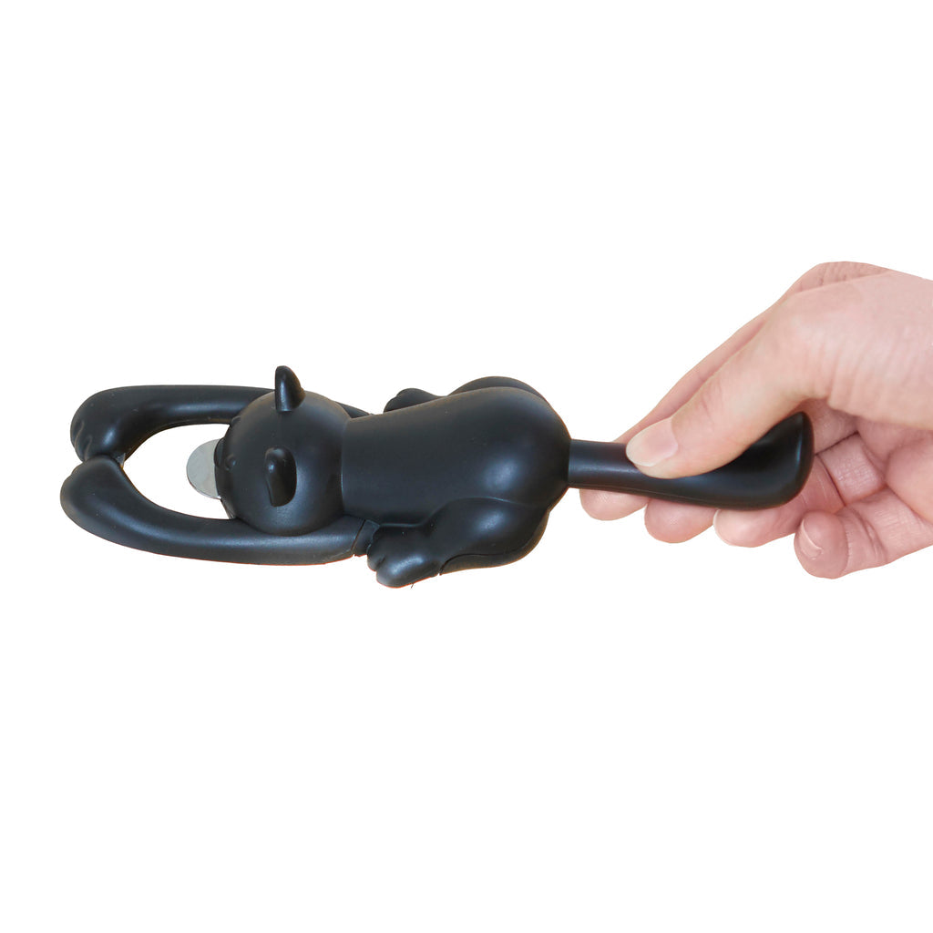Zwarte Balvi Curious Cat flesopener in kattenvorm, vastgehouden in de hand