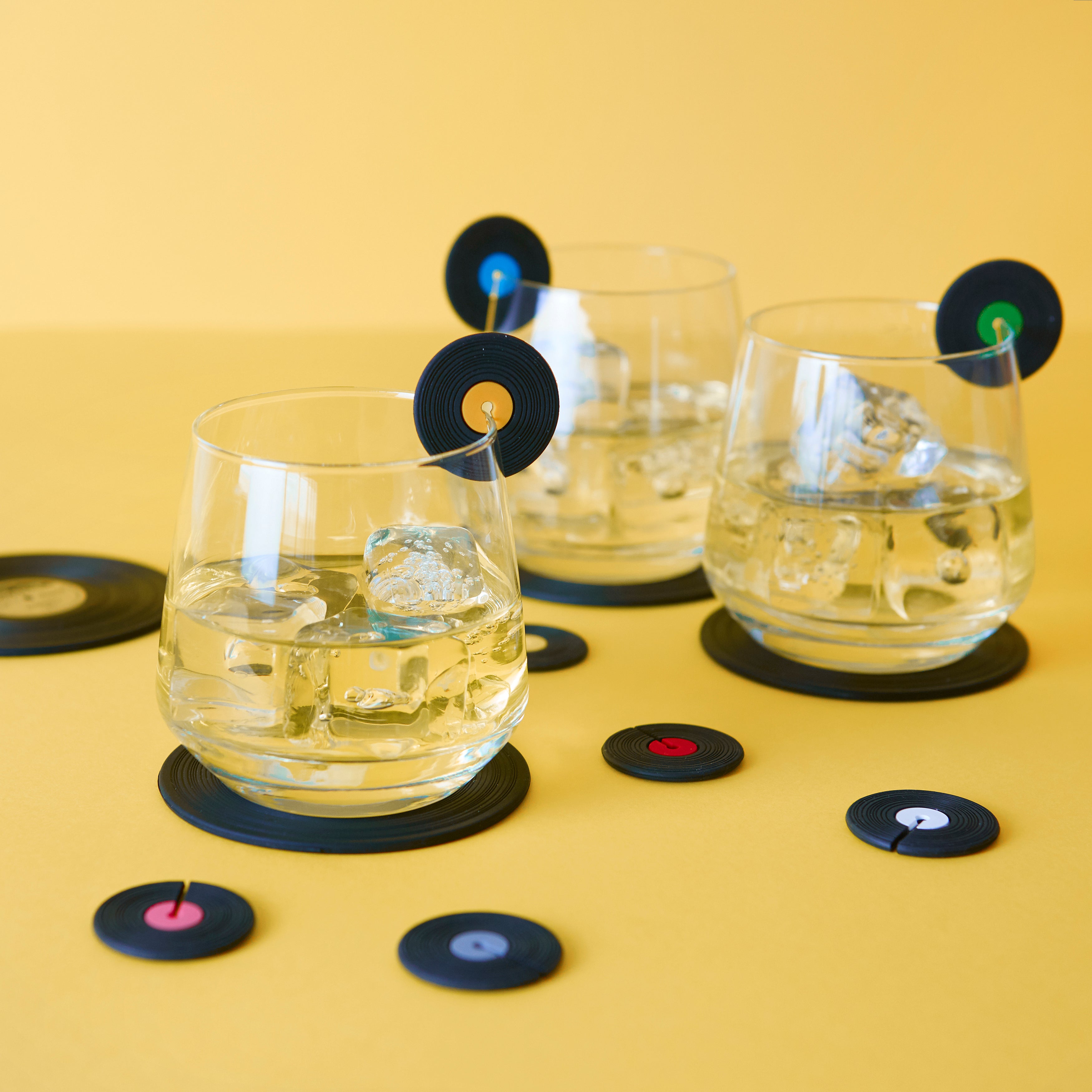 Balvi Glasmarkers Greatest Hits Siliconen - 8 stuks, aan glazen met ijsblokjes, op oranje achtergrond