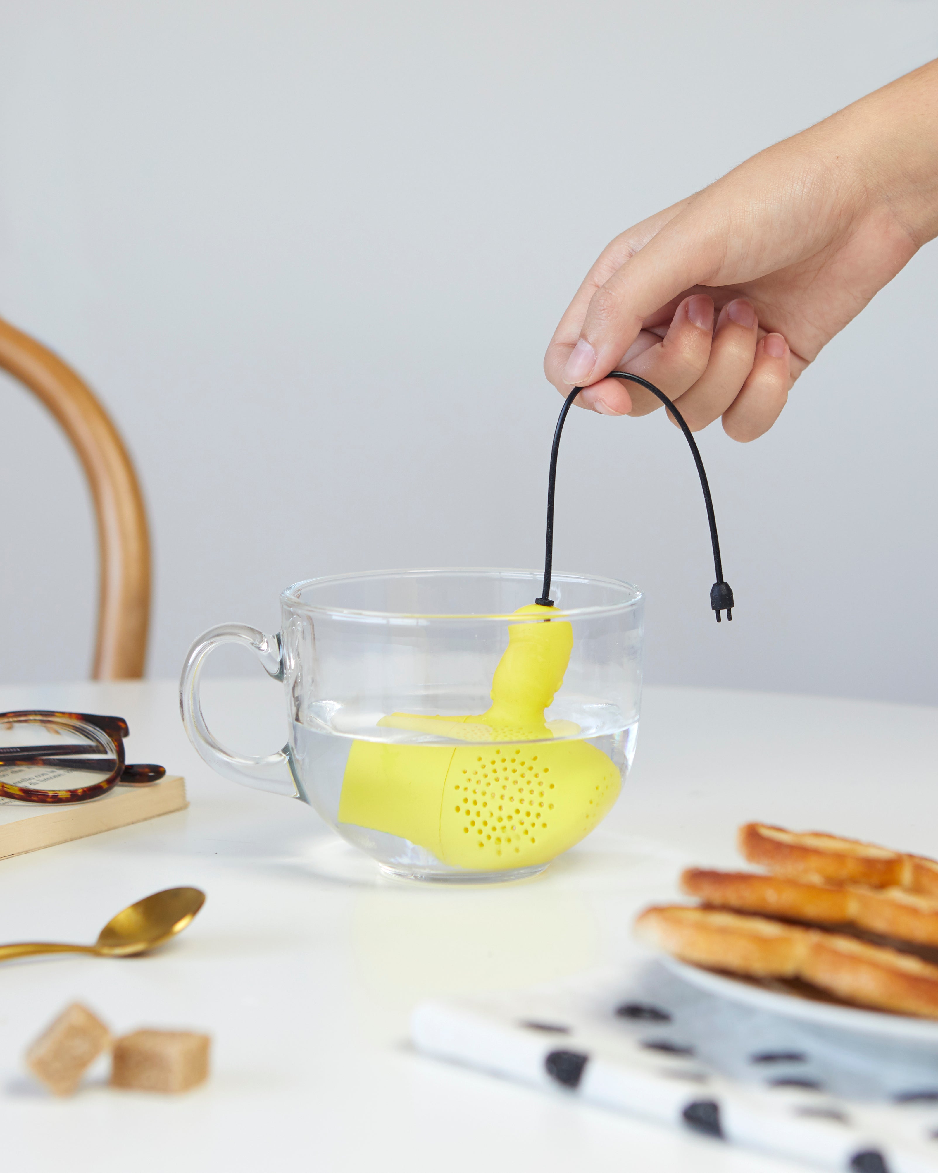 Balvi Thee-ei ElectriciTEA, vastgehouden boven een kopje thee