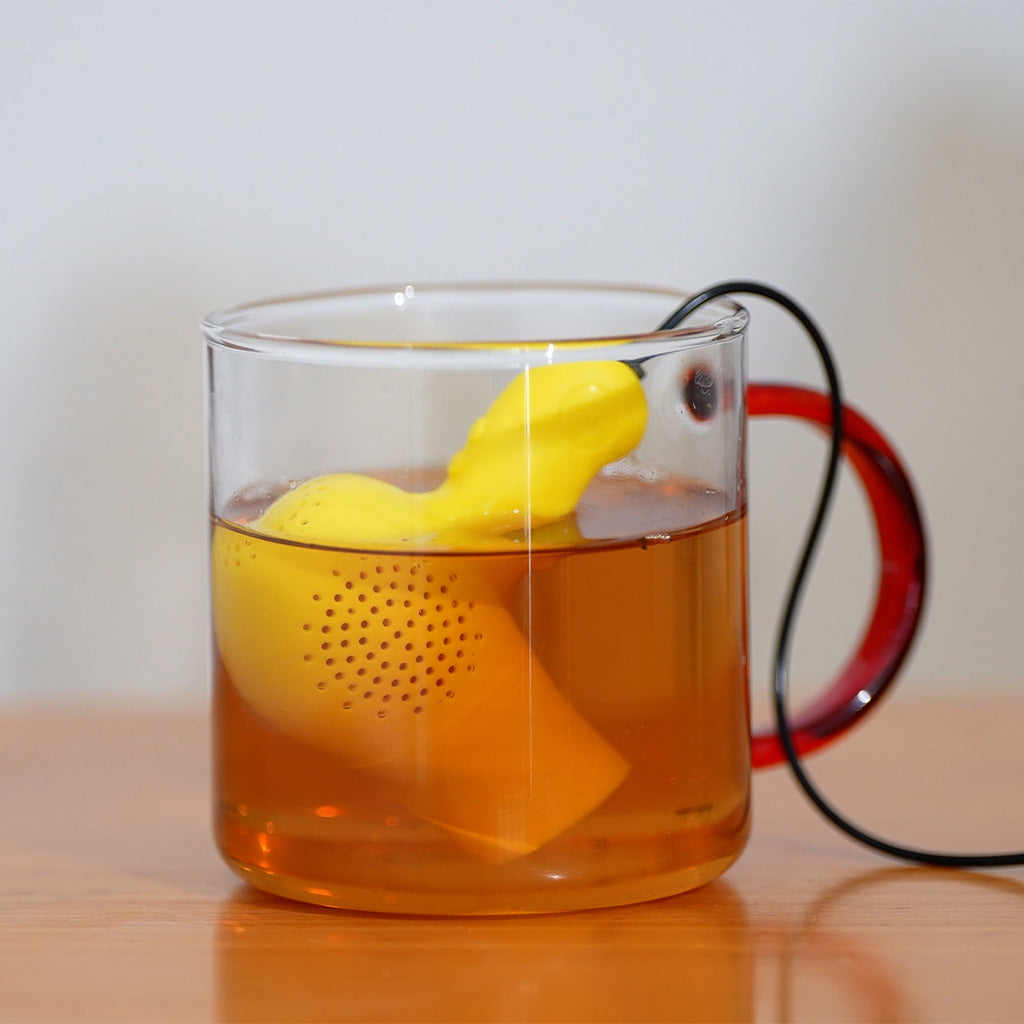 Balvi Thee-ei ElectriciTEA, in een glazen mok met rood handvat, gevuld met hete thee