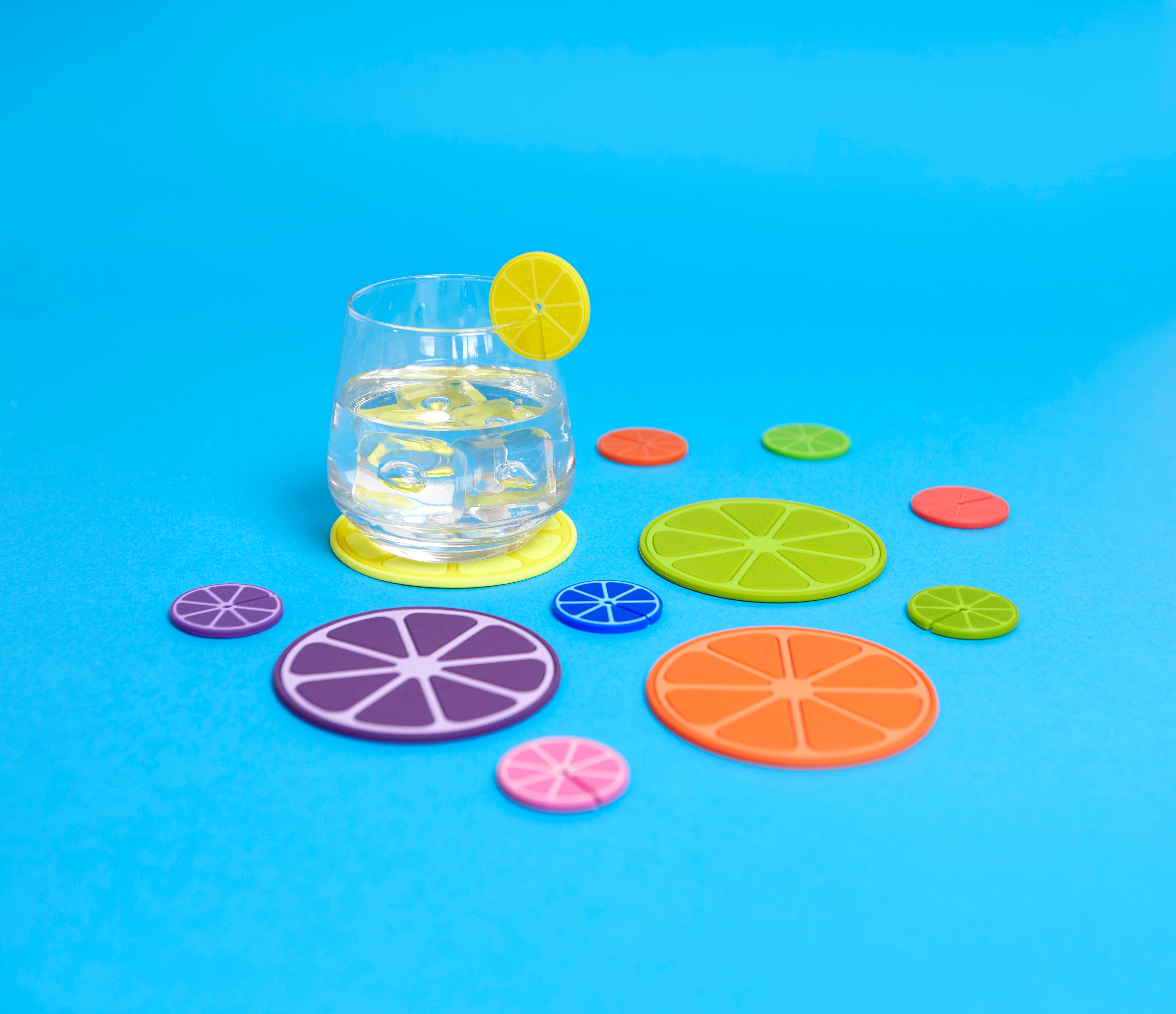 Balvi Onderzetters Fruit Party - 4 stuks, op blauwe achtergrond met glas