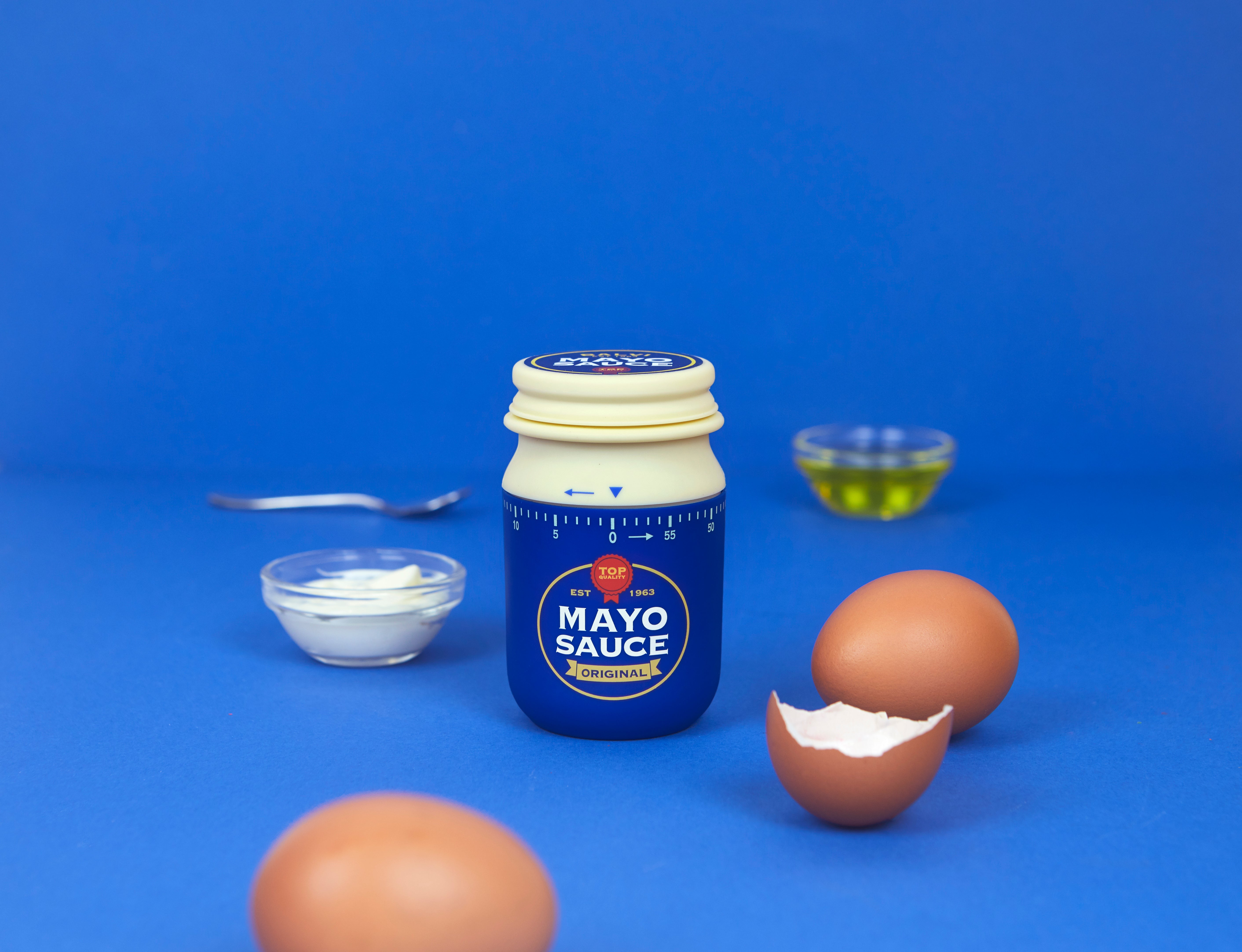 Balvi Kookwekker Mayonaise, op blauwe achtergrond naast een kom en eieren
