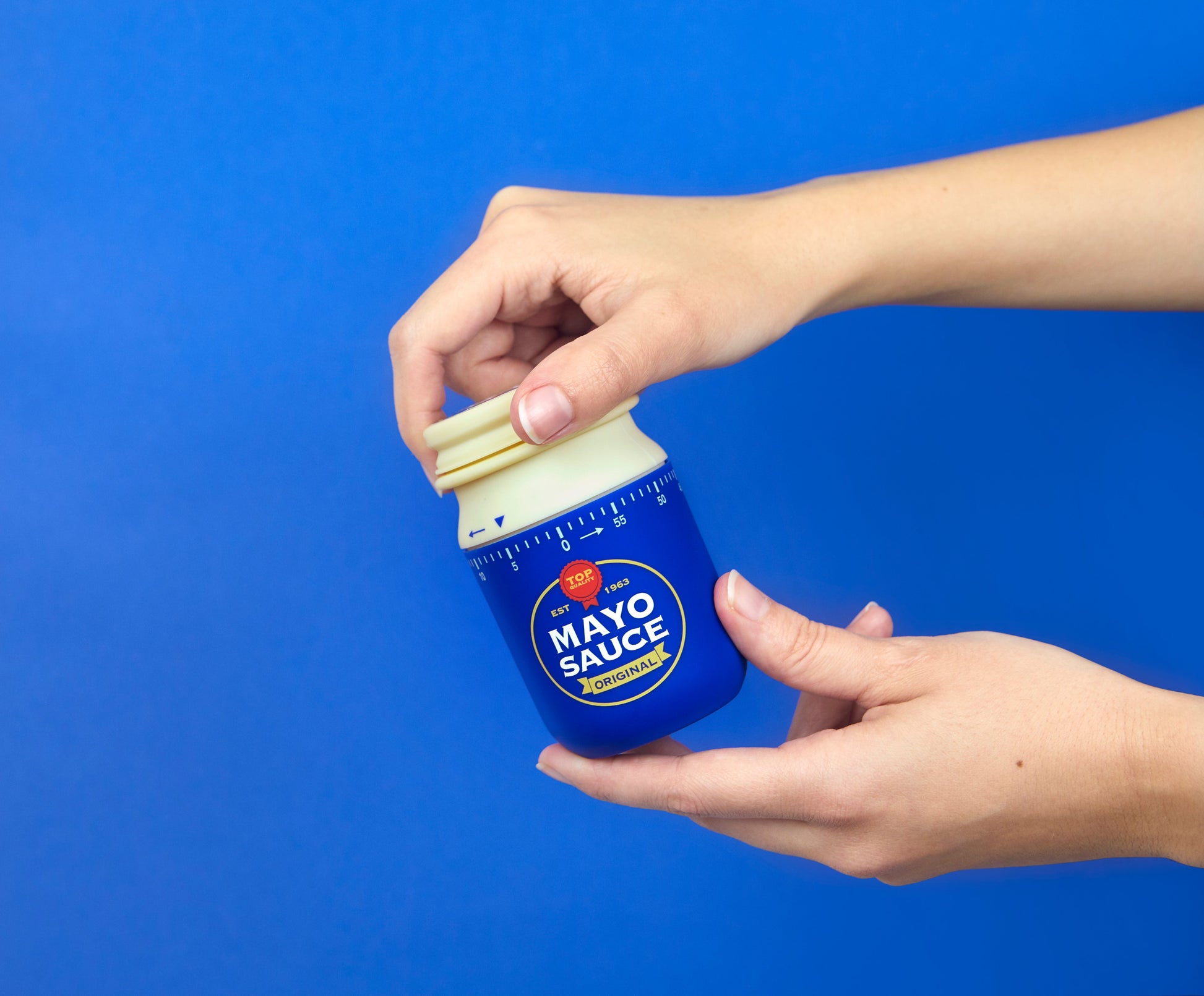 Balvi Kookwekker Mayonaise, op blauwe achtergrond, hand draait aan de bovenkant