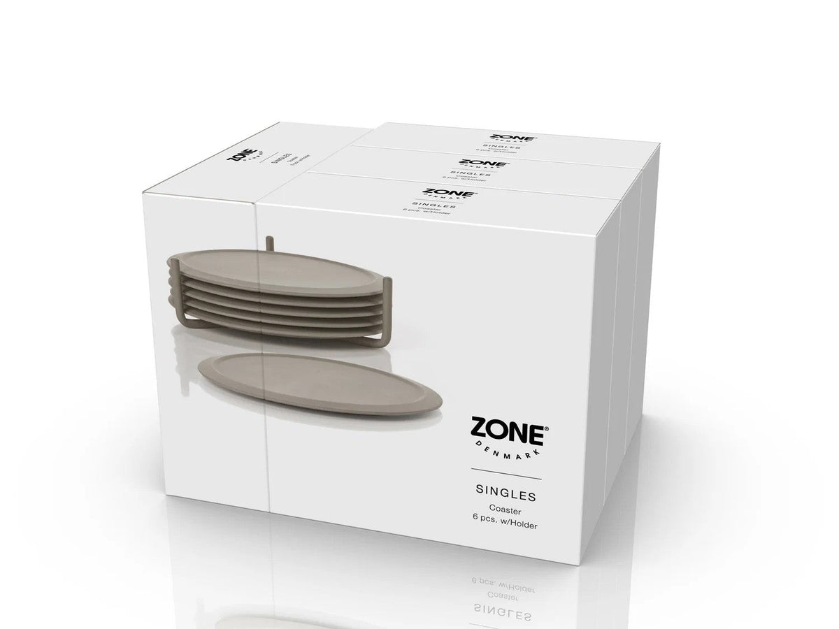 Drie gestapelde witte dozen met Zone Denmark Singles, Coaster 6 pcs. w/Holder en taupe onderzetters in houder