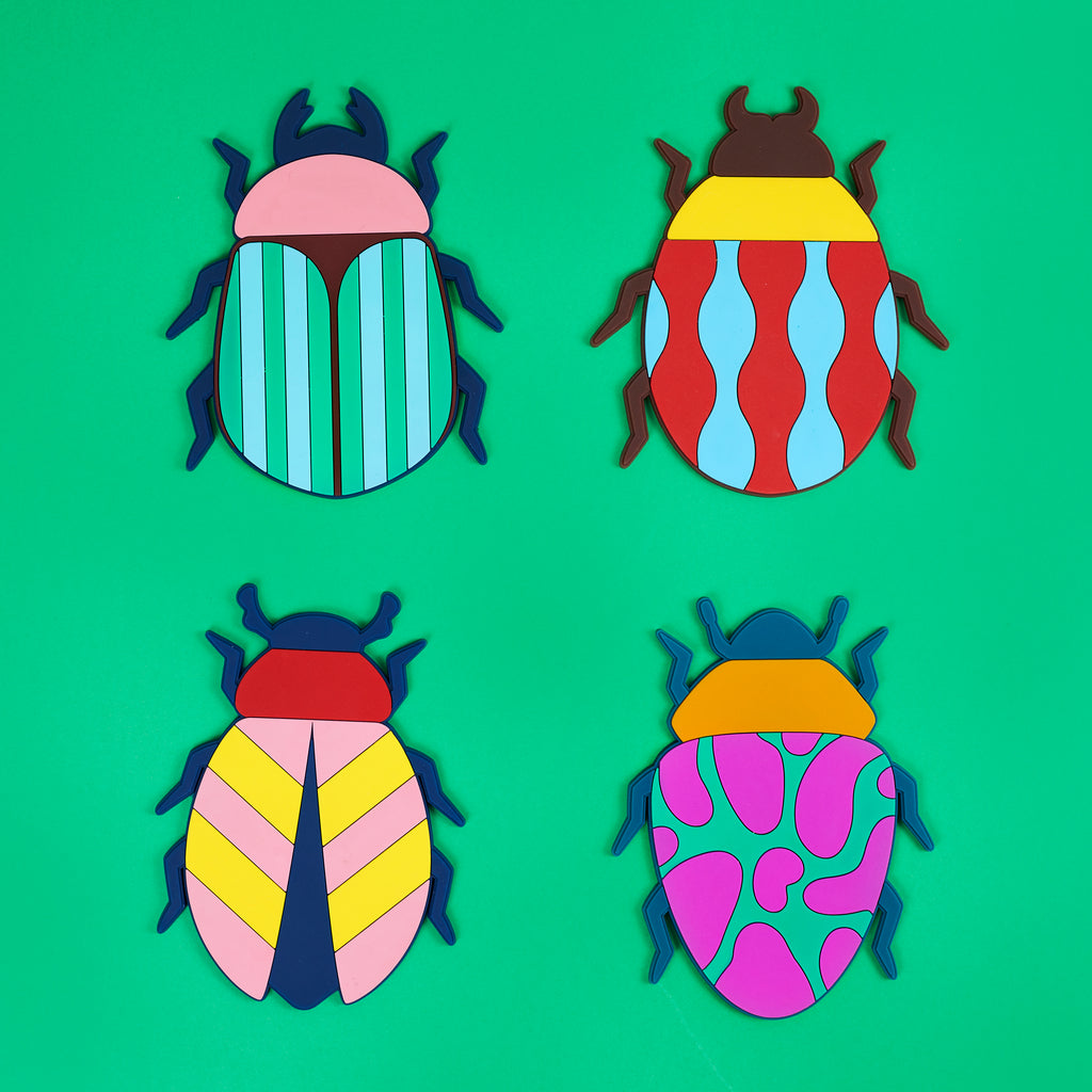 Balvi Onderzetters The Beetles - 4 stuks, bovenaanzicht van vier kevers met streep-, golf-, pijl- en vlekmotief op een groene achtergrond