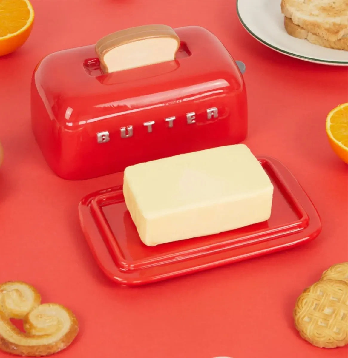 Balvi Botervloot Toasty Rood, op rode achtergrond met sinaasappel en crackers