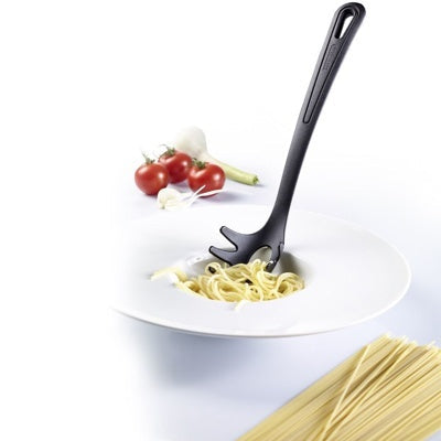 Westmark Gentle Spaghettilepel, zwart, in een bord met spaghetti naast tomaten en knoflook
