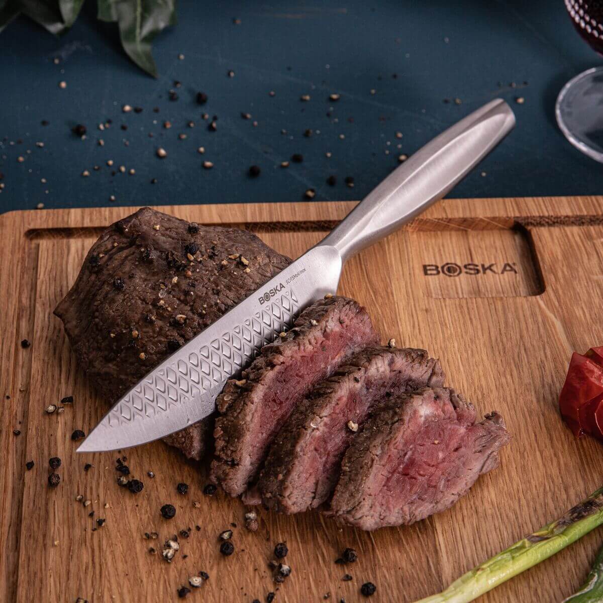 Boska Monaco+ Steakmes snijdt door een medium-rare steak op een houten plank