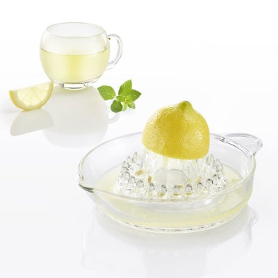 Westmark Citruspers - Glas, transparant, met halve citroen erop geperst naast een kopje thee met munt