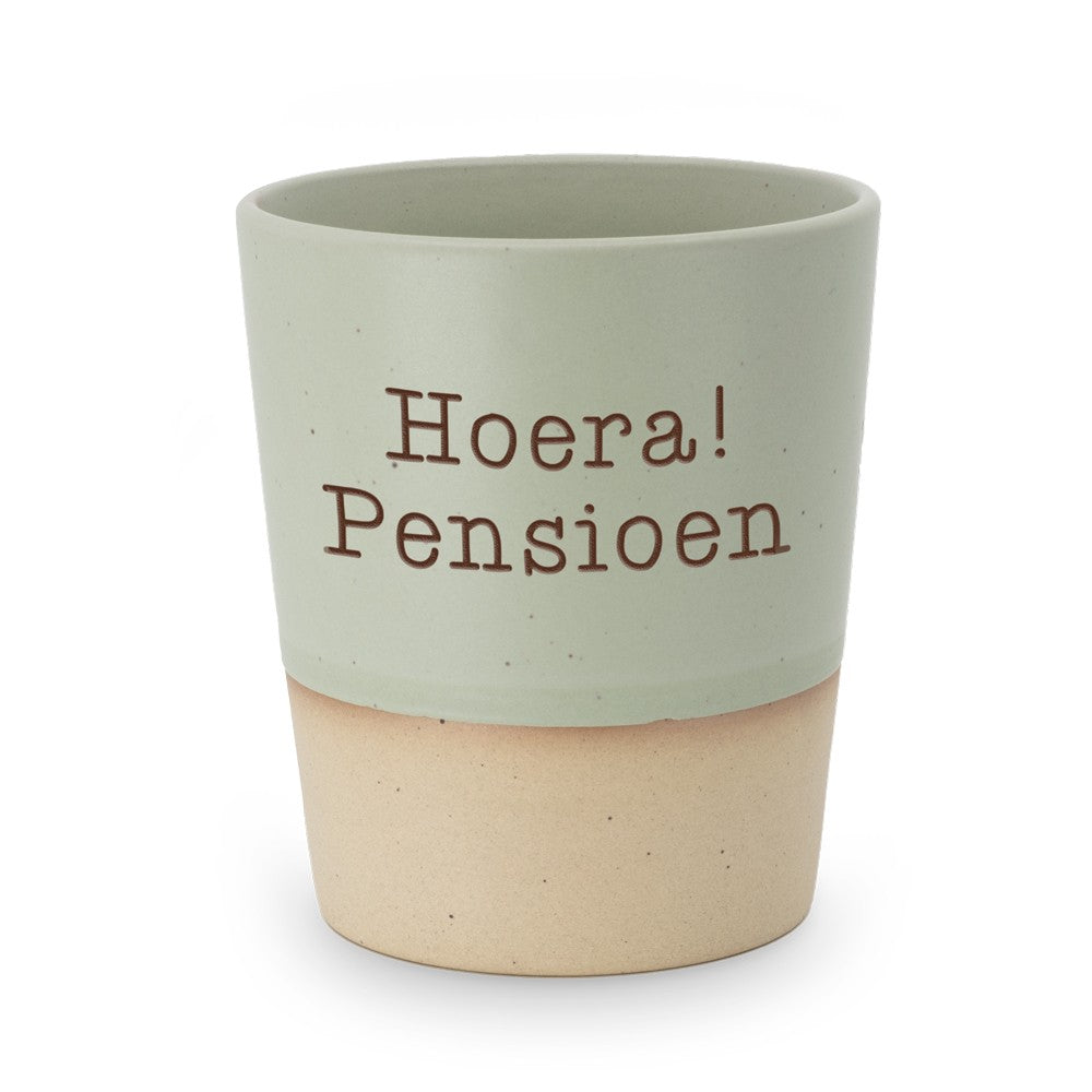 Miko Special Ceramics beker met saliegroene bovenkant en ingegraveerde tekst "Hoera! Pensioen" in twee regels, zandkleurige onderrand, op witte achtergrond.