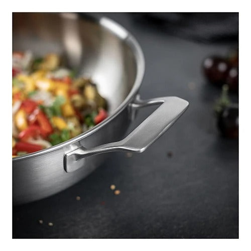 Detailopname van de hulpgreep aan de binnenzijde van de Culinary 5-Ply wok met deksel 28 cm, met het roerbakgerecht van groente en noedels op de voorgrond.