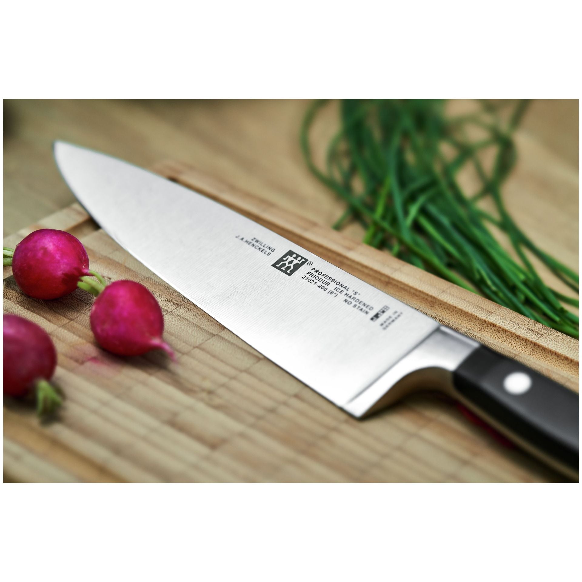Zwilling Professional S koksmes uit de messenset naast verse radijsjes en bieslook