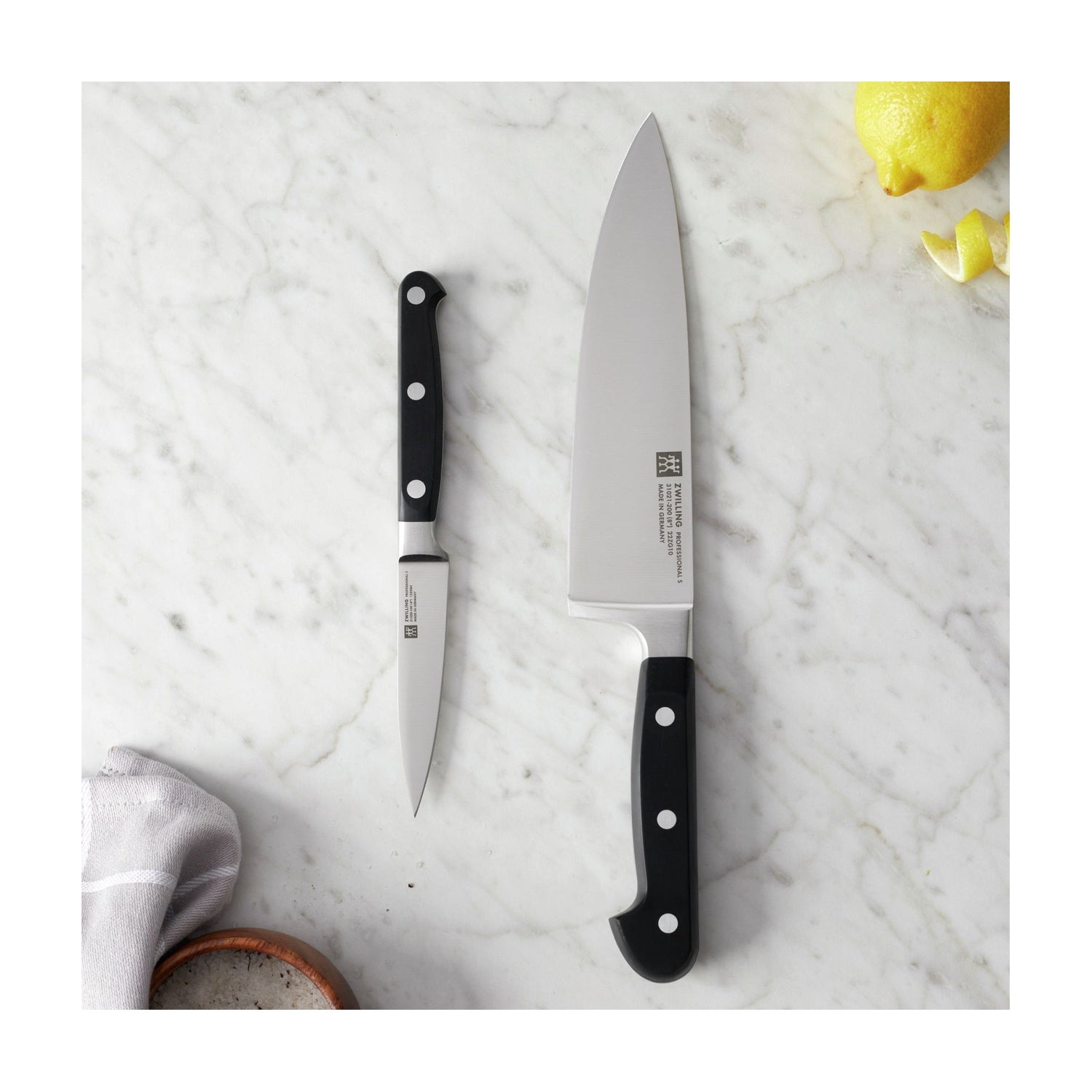 De 2 messen van de Zwilling Professional S Messenset op een marmeren aanrecht met citroen