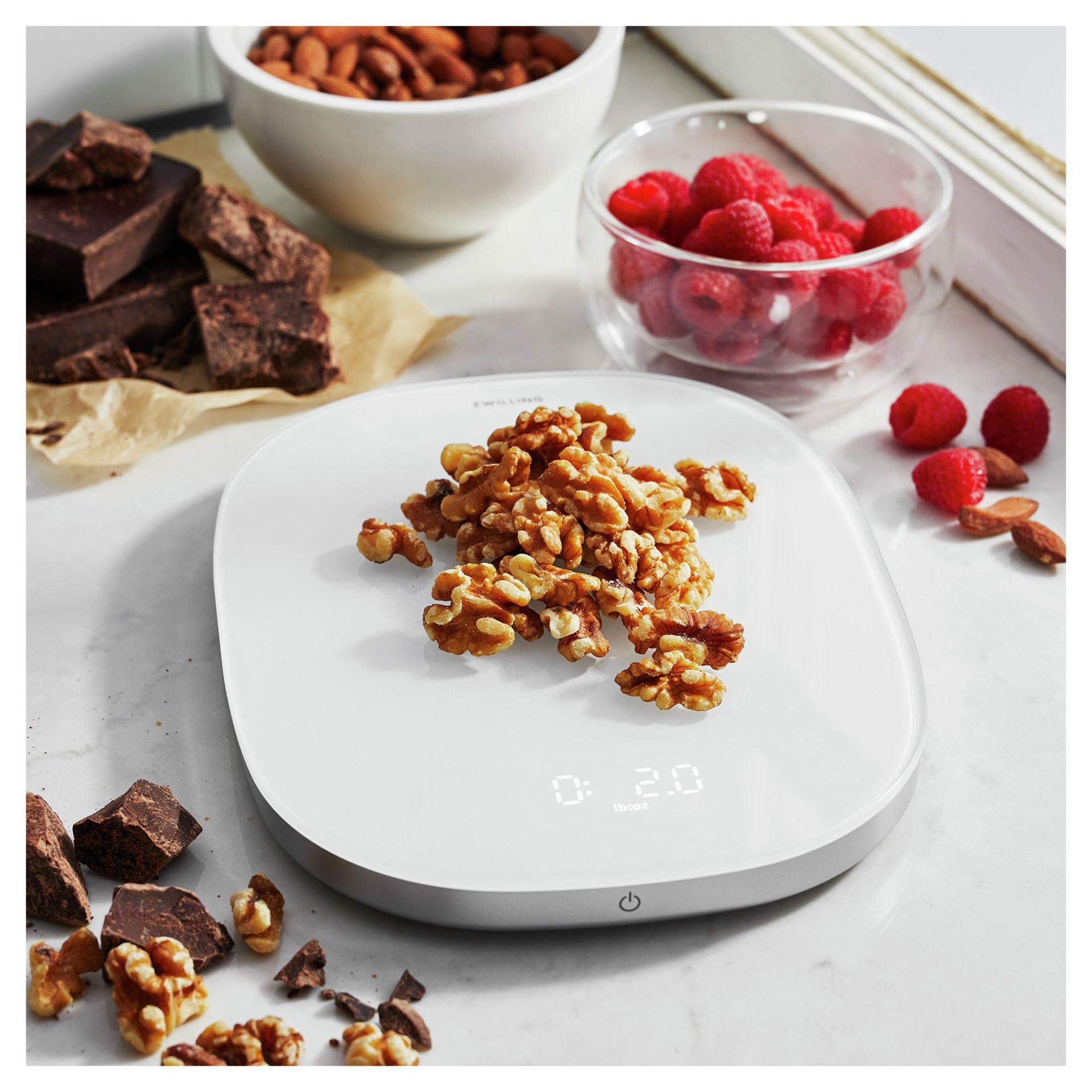 Zwilling Enfinigy Keukenweegschaal met walnoten, chocolade en frambozen erop
