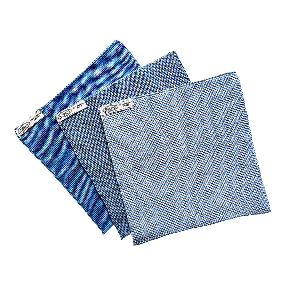 Solwang Design Vaatdoekjes set van 3 - IJsblauw Combi drie doekjes gewaaierd tegen elkaar aan in drie tinten ijsblauw, van helder blauw via middenblauw naar een lichte, bijna witachtige blauwtint, met het Solwang-label aan elk doekje.