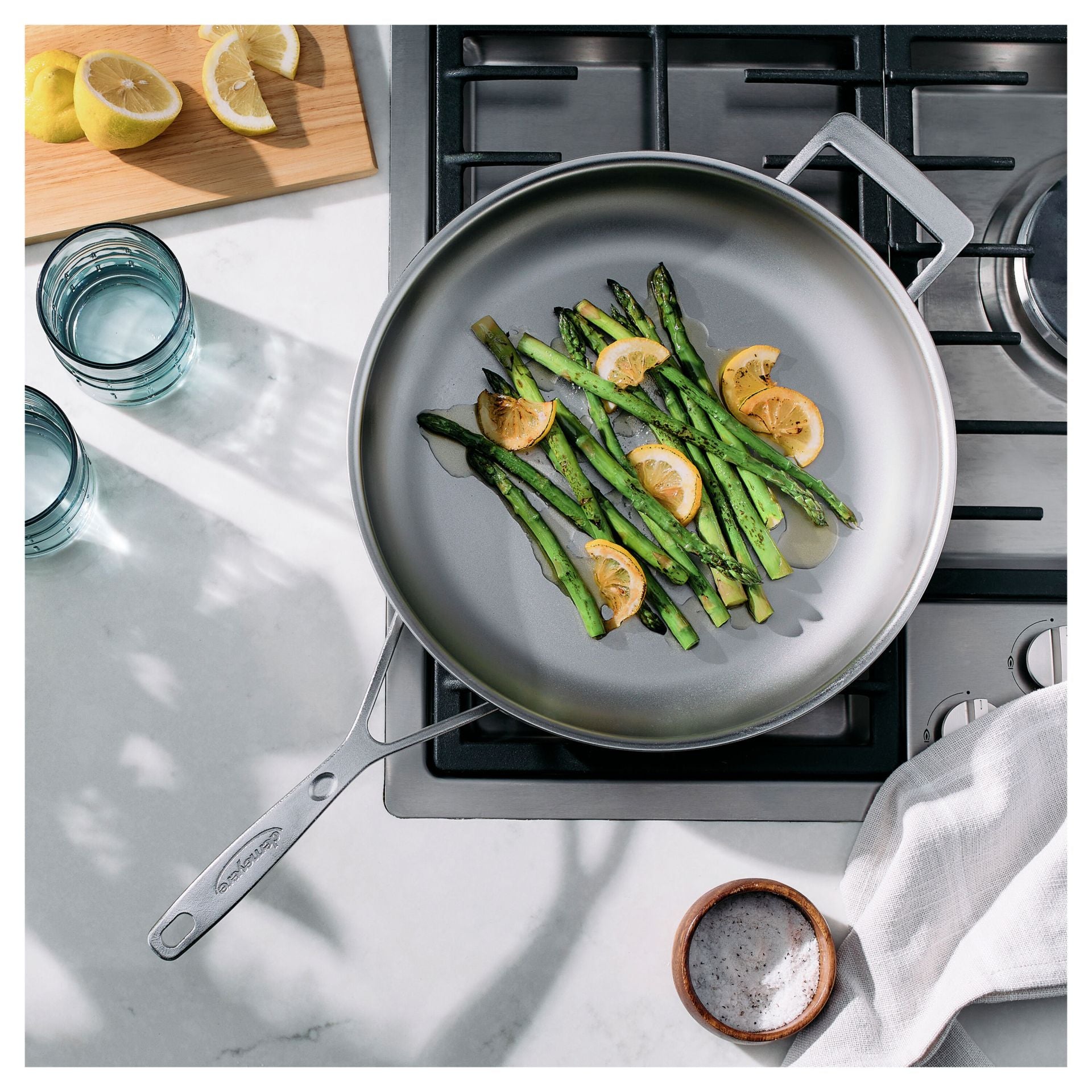 Asperges en citroen worden gebakken in de Demeyere Industry 5 Koekenpan NanoTouch 32 cm op een gaskookplaat