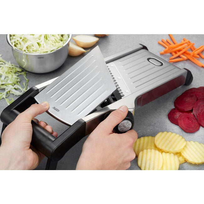 GEFU Mandoline Welo, close-up van twee handen die aardappel in schijfjes snijden op het mandolineblad, met rode kool, wortel en biet ernaast