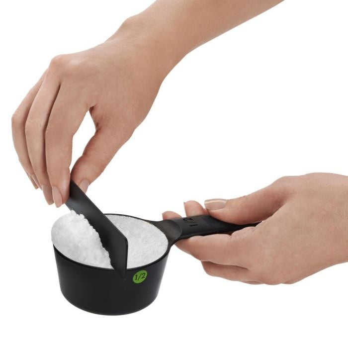 OXO Good Grips Maatschepset in gebruik, hand strijkt suiker glad met de losse afstrijker