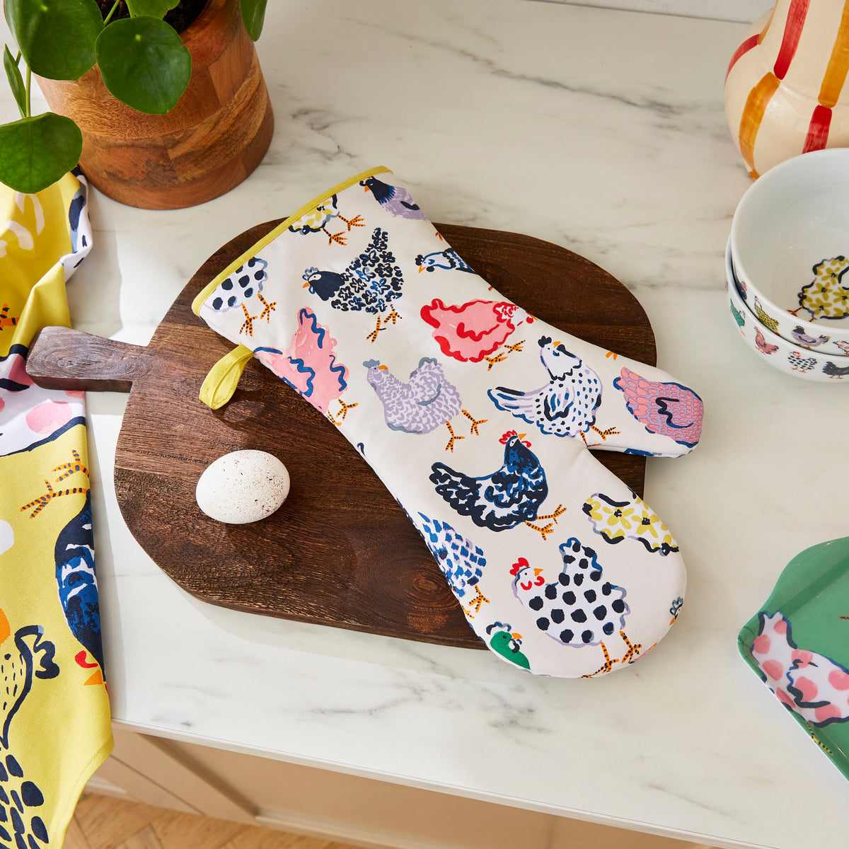 Ulster Weavers Ovenwant Katoen - Chick Chicken, ovenwant op een houten snijplank met een ei