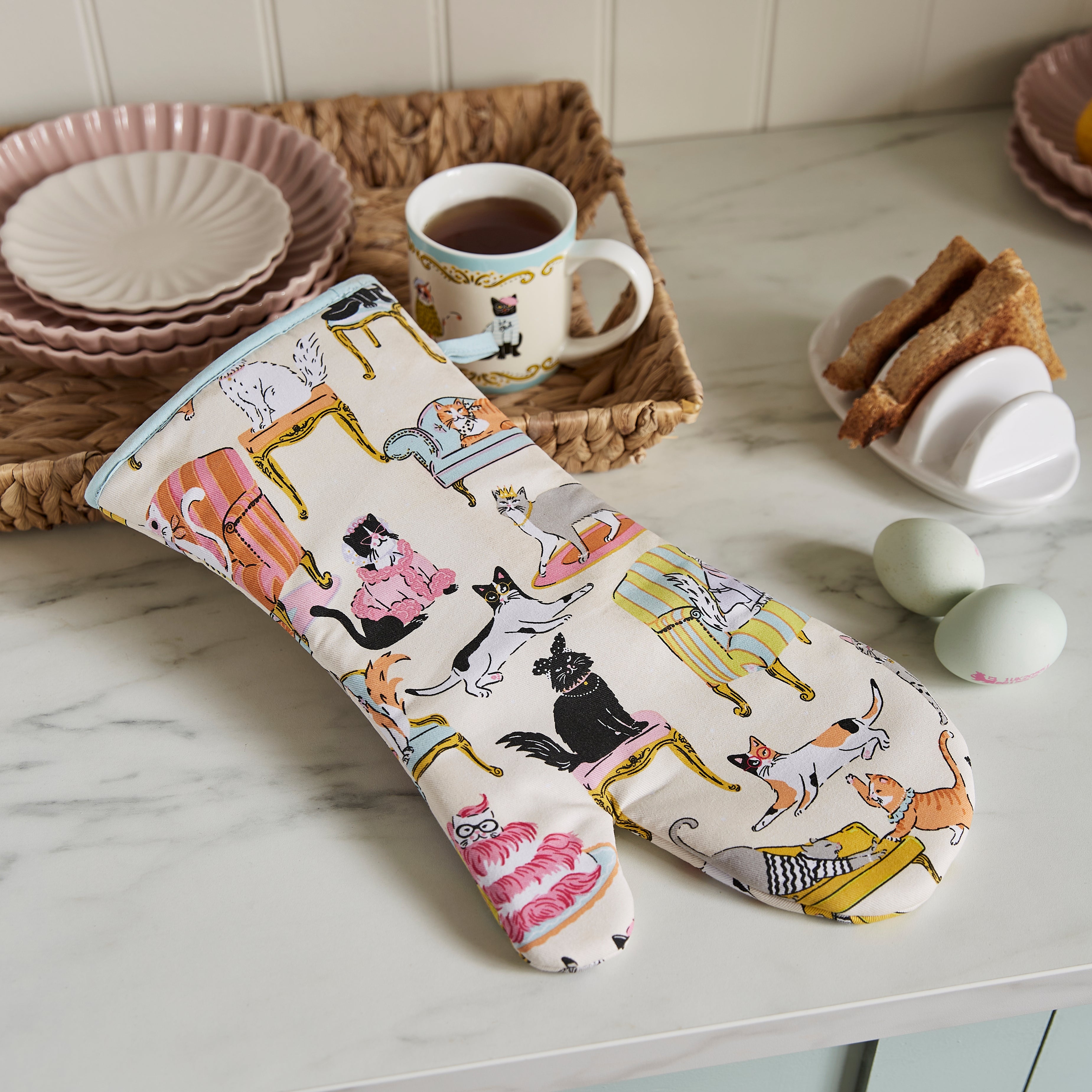 Ulster Weavers Ovenwant Katoen - Cool Cats, ovenwant naast kopjes en een schaaltje eieren