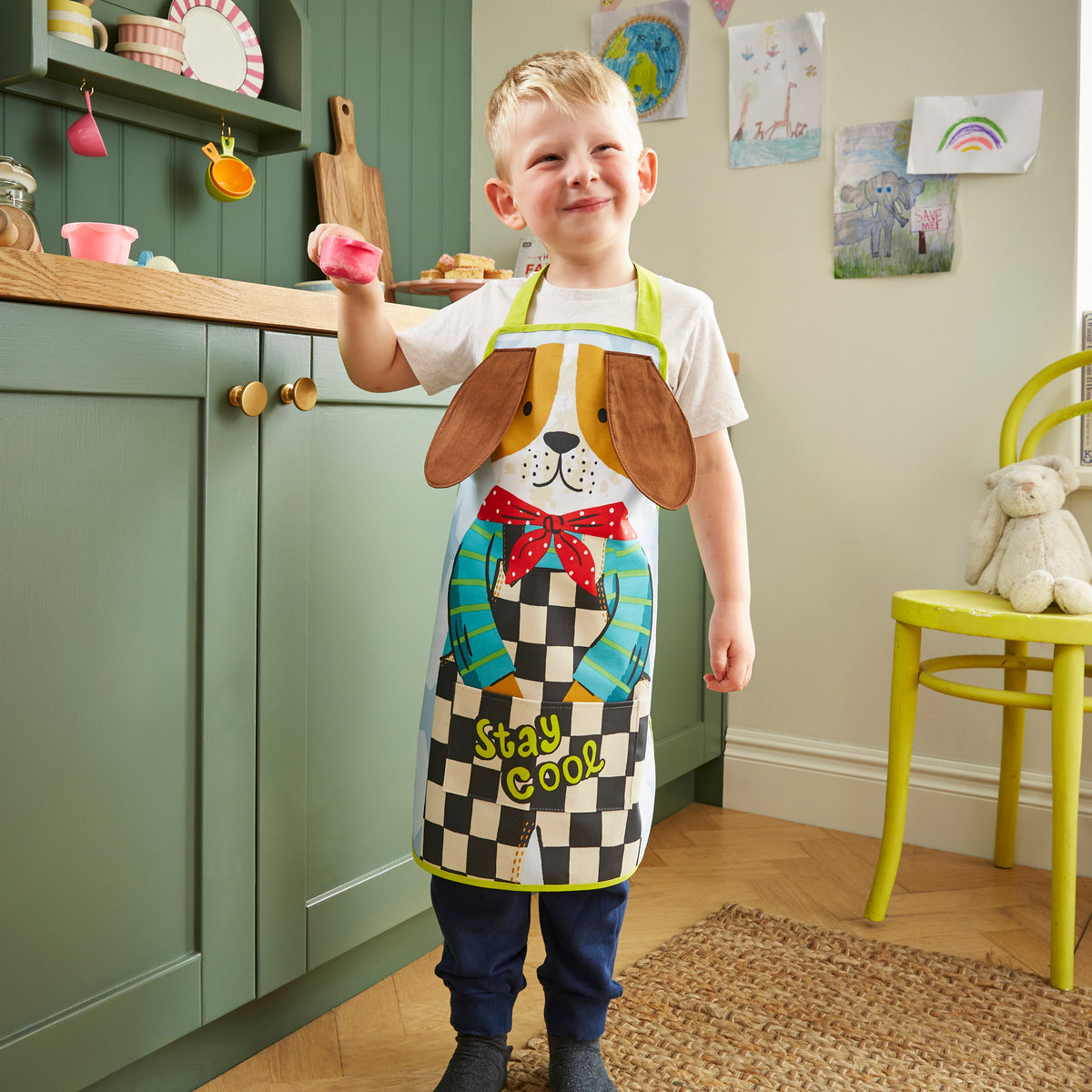 Ulster Weavers Kinderschort - Dexter Dog, kind draagt de kinderschort in de keuken