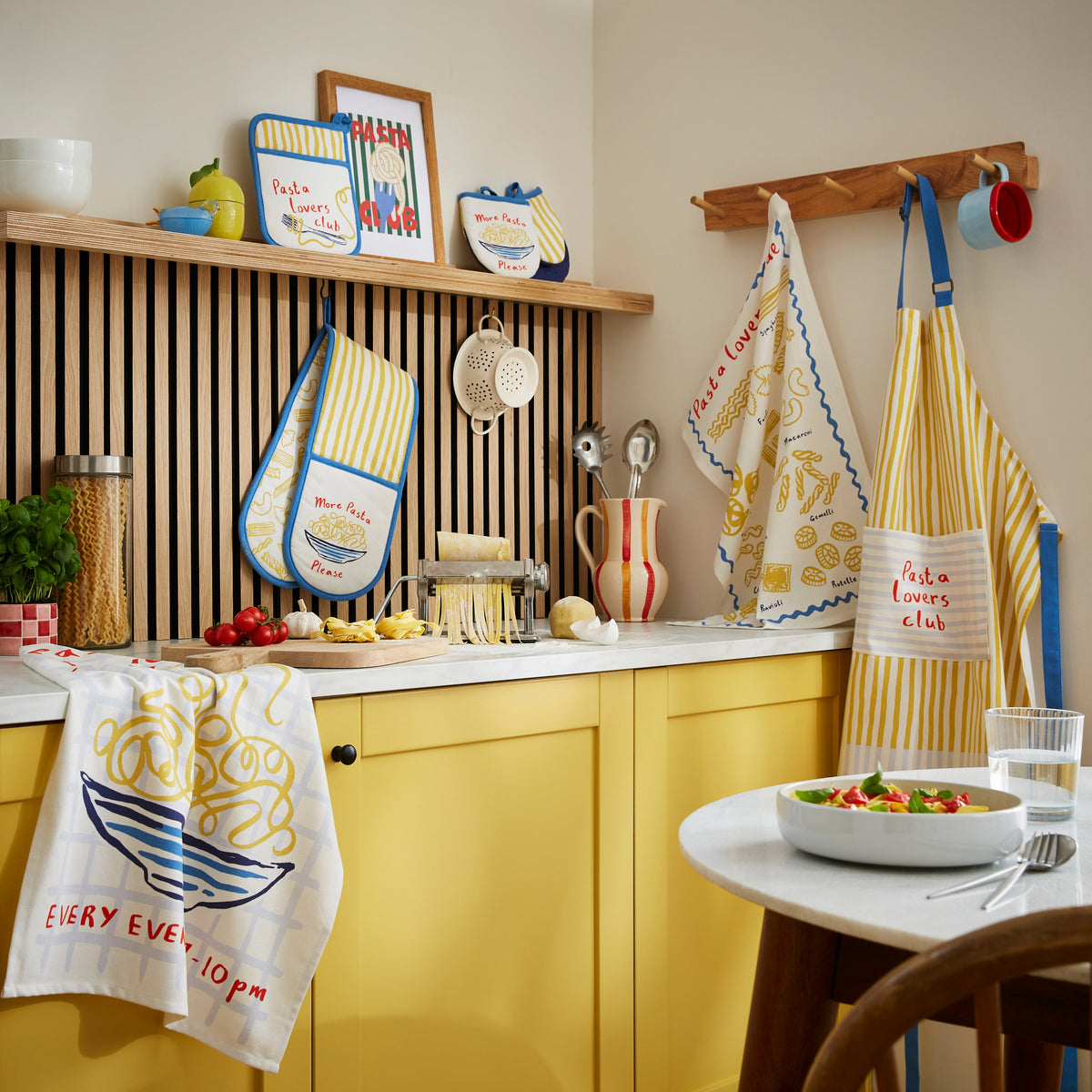 Ulster Weavers Ovenwantjes - Pasta Lovers Club, ovenwantjes, theedoek en schort op het aanrecht