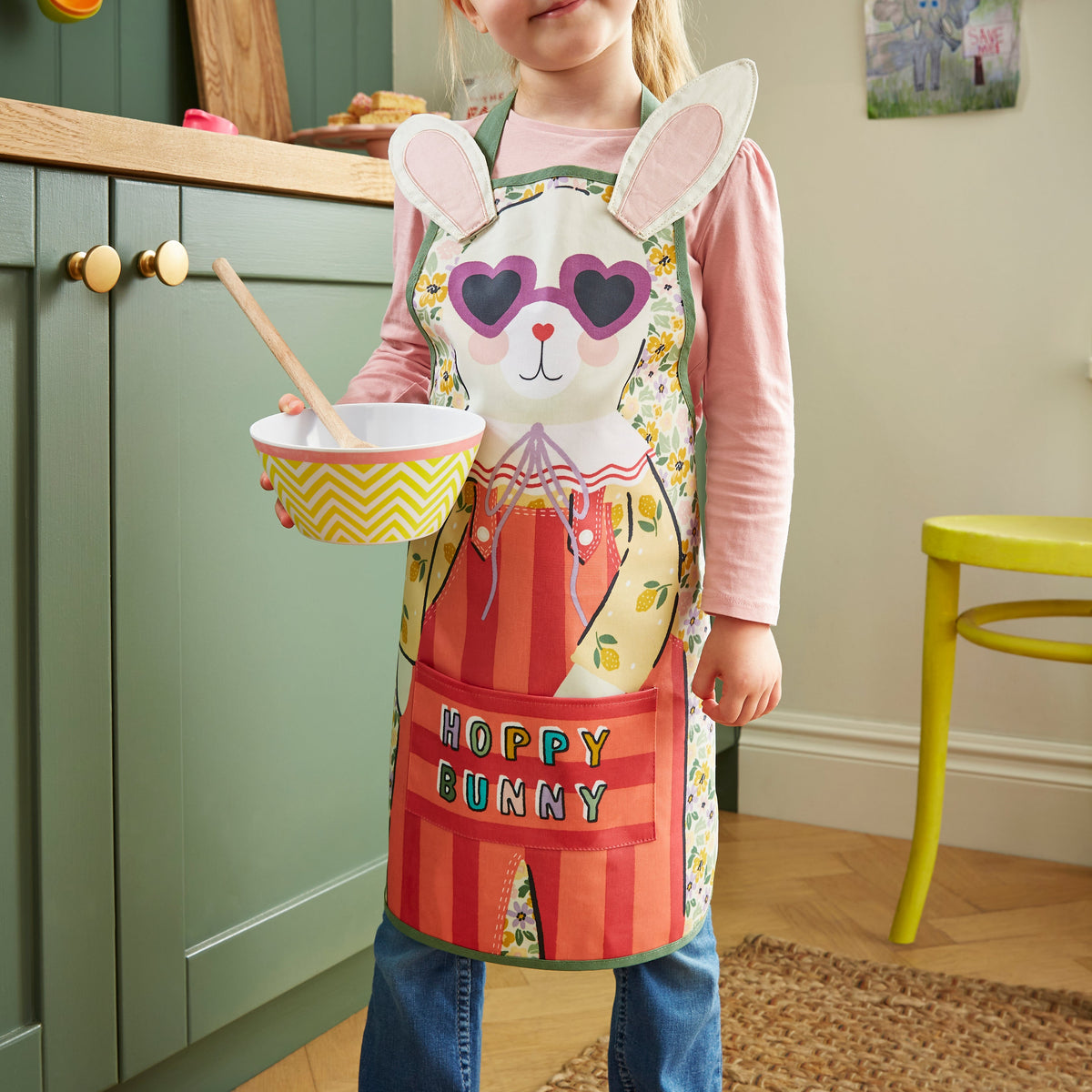 Ulster Weavers Kinderschort - Rosie Rabbit, kind draagt de kinderschort met een mandje