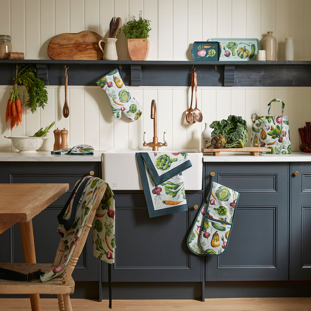 Ulster Weavers PVC Schort - Vegetable Medley, pvc-schort, theedoek en ovenwant op een plank in de keuken