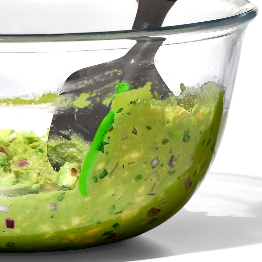OXO Good Grips Smash & Scoop Avocadohulp, close-up tijdens bereiden van guacamole met rode ui in glazen kom