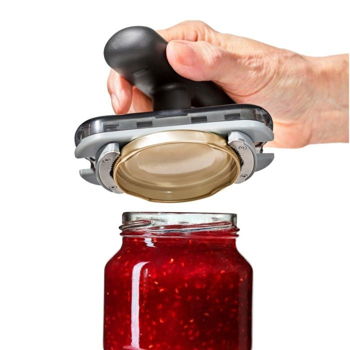 OXO Good Grips Potopener, geklemd om deksel van pot jam met rood fruitbeleg