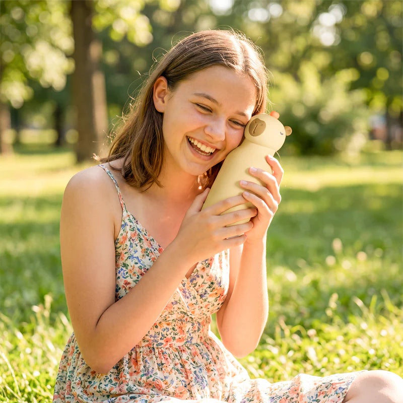 Vrouw in een park lacht en houdt de Asobu Bestie Thermosfles Capybara vast
