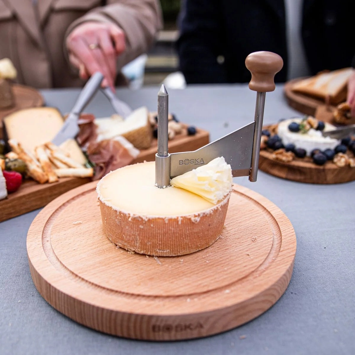 Boska Amigo Kaaskruller in gebruik tijdens een borrel, op tafel met brood en vleeswaren