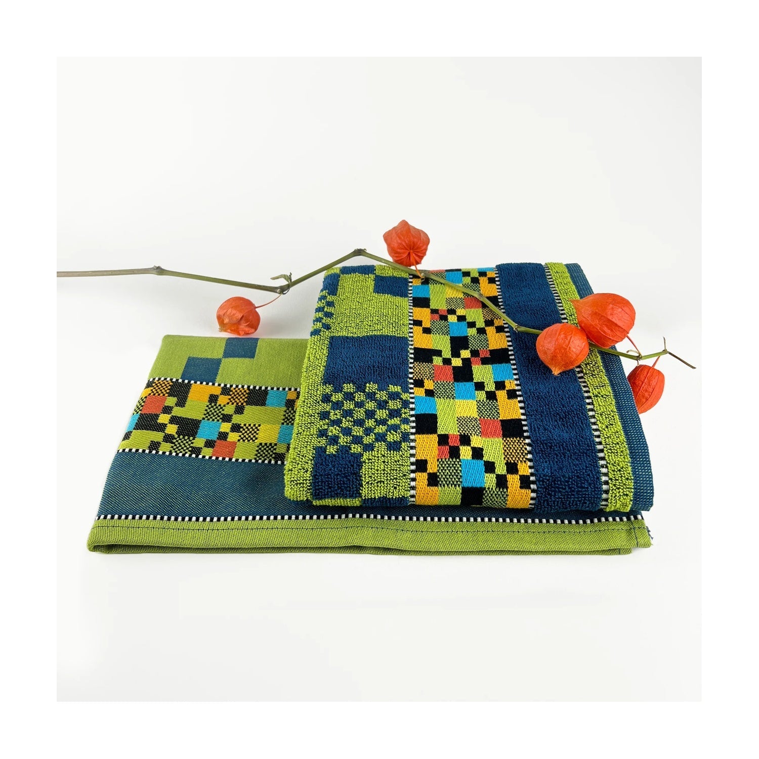 Mariëtte Wolbert Keukendoek Soft Square Petrol, gevouwen met een tak sierlampionplant (physalis) erop