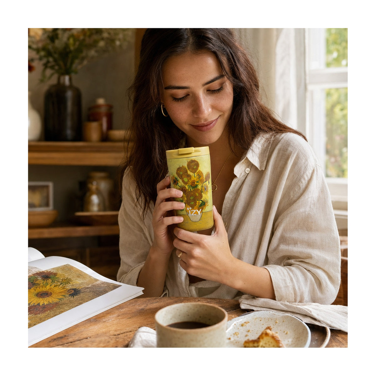Vrouw drinkt uit de IZY Thermosbeker Zonnebloem Van Gogh aan een houten tafel