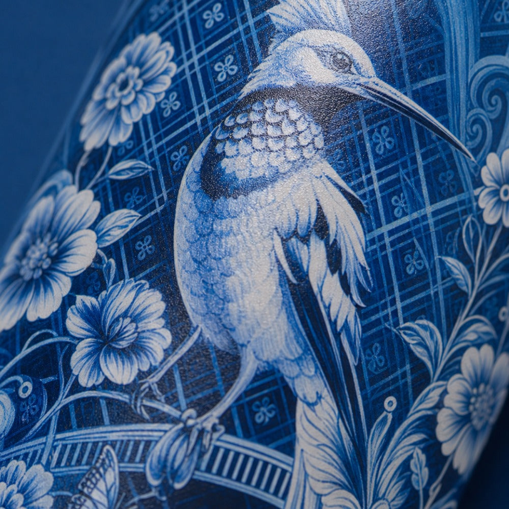 Close-up van het witte vogel- en bloemenmotief op de IZY Thermosbeker Royal Blue