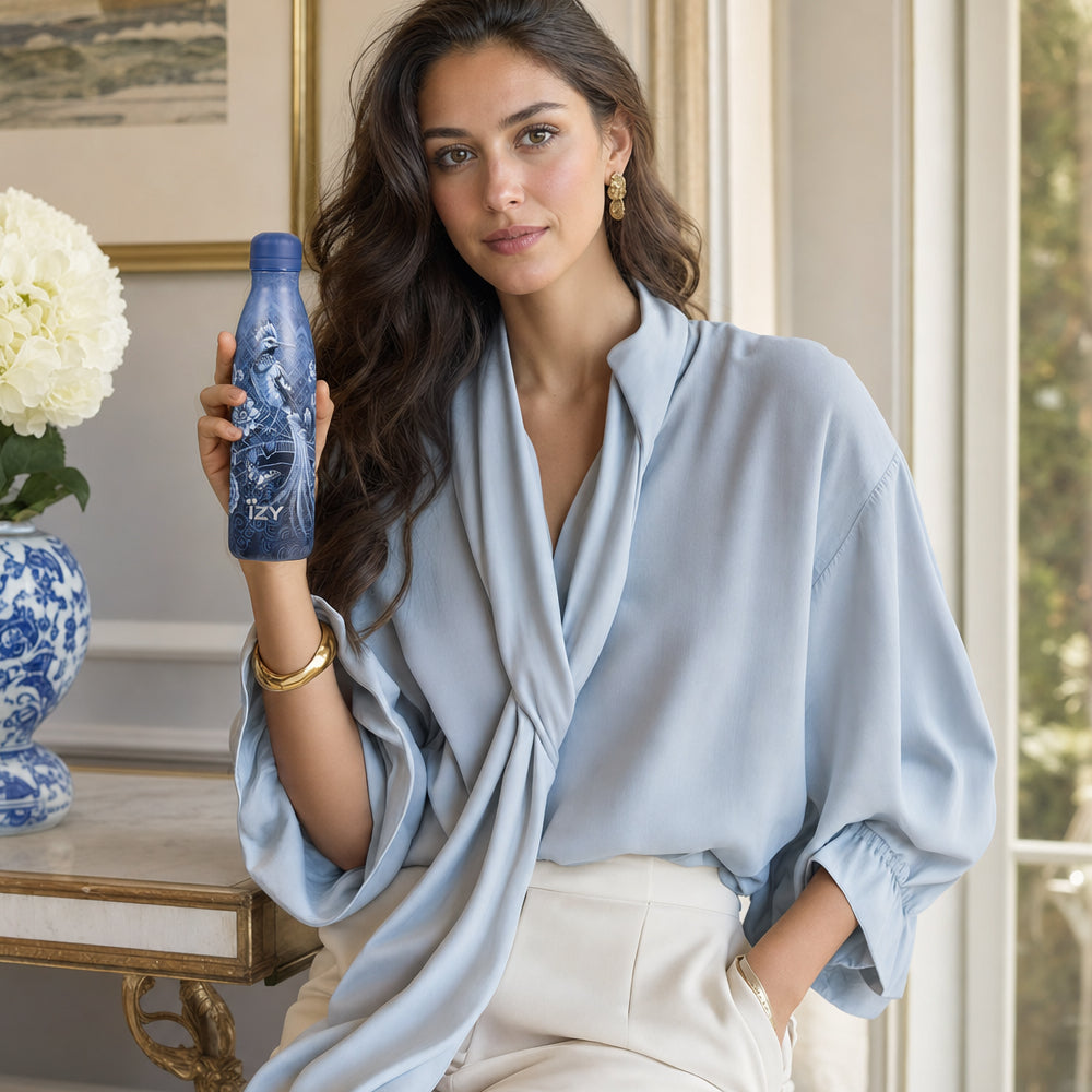 Vrouw met bloemen in de hand houdt de blauwe IZY Thermosfles Royal Blue vast